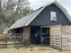 Spacious black and wood barn with horses in a rural setting at 6615 Broken Arrow S Trl, Lakeland, FL 33813