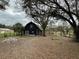 Exterior view of the barn surrounded by fencing and trees at 6615 Broken Arrow S Trl, Lakeland, FL 33813