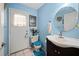 Unique bathroom with blue walls, vanity sink, and a door to the outside at 6615 Broken Arrow S Trl, Lakeland, FL 33813