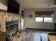 Living area showcasing a brick fireplace and mantel, tile floor, and natural light from a nearby window at 6615 Broken Arrow S Trl, Lakeland, FL 33813