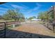 View of horse pen area with wooden fence, metal gate and water trough surrounded by trees at 6615 Broken Arrow S Trl, Lakeland, FL 33813