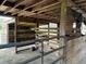 Interior view of a wooden horse stall with hay covered floor and partial view of a gate at 6615 Broken Arrow S Trl, Lakeland, FL 33813