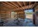 Interior view of the horse stall with a dirt floor, hay, wood construction, and gated entrance at 6615 Broken Arrow S Trl, Lakeland, FL 33813