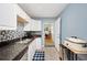 Kitchen featuring granite countertops, stainless steel appliances, and blue accent wall at 6615 Broken Arrow S Trl, Lakeland, FL 33813