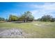 Sprawling green field accented with mature trees under a clear blue sky at 6615 Broken Arrow S Trl, Lakeland, FL 33813