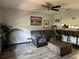 Comfortable living room featuring wood-look flooring, a ceiling fan, and a small seating arrangement at 6615 Broken Arrow S Trl, Lakeland, FL 33813