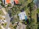 Aerial view of a home with a pool, surrounded by lush greenery and mature trees in a residential neighborhood at 7410 Locksley Ln, Lakeland, FL 33809