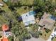 Aerial view of property showcasing a screened in pool, lush trees, and private yard at 7410 Locksley Ln, Lakeland, FL 33809