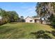 Large grassy backyard showcasing the home's rear exterior, pool enclosure, and privacy fence at 7410 Locksley Ln, Lakeland, FL 33809