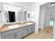 Bathroom with double sink vanity, large mirror, and tiled floors next to a toilet and tub/shower combo at 7410 Locksley Ln, Lakeland, FL 33809