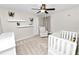 Bedroom with neutral walls, floating shelves, white crib and plush chair at 7410 Locksley Ln, Lakeland, FL 33809