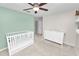 Bedroom with green walls, floating shelves, white crib and changing table at 7410 Locksley Ln, Lakeland, FL 33809