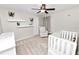 Cozy Bedroom with white walls, carpet, a crib, shelving, and a comfortable chair at 7410 Locksley Ln, Lakeland, FL 33809