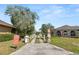 Private driveway leading to a grand home, surrounded by lush landscaping and mature trees at 7410 Locksley Ln, Lakeland, FL 33809