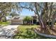 Charming home featuring a well-manicured lawn, mature trees, and a welcoming entrance at 7410 Locksley Ln, Lakeland, FL 33809