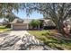 Inviting home with lush landscaping, mature trees, a driveway, and a well-kept front yard at 7410 Locksley Ln, Lakeland, FL 33809