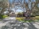 Charming single Gathering home featuring mature trees, well-manicured lawn, and a two-car garage at 7410 Locksley Ln, Lakeland, FL 33809