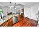 An open kitchen features an island with stainless steel appliances and rich wooden floors at 7410 Locksley Ln, Lakeland, FL 33809