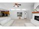 Open living room with neutral decor, ceiling fan, and view into the kitchen at 7410 Locksley Ln, Lakeland, FL 33809