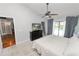 Bright main bedroom featuring carpeting, ceiling fan, and door leading to hardwood floors at 7410 Locksley Ln, Lakeland, FL 33809