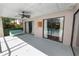 Relaxing screened patio with ceiling fan, swing seat, and sliding glass doors overlooking the refreshing pool at 7410 Locksley Ln, Lakeland, FL 33809