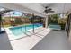 A screened-in pool area features a clean pool and a relaxing porch swing with a ceiling fan at 7410 Locksley Ln, Lakeland, FL 33809