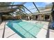 Large screened-in pool, patio with a grill, and a swing with glass doors leading inside at 7410 Locksley Ln, Lakeland, FL 33809