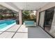Screened-in porch with a hanging swing sofa next to the pool and sliding glass doors at 7410 Locksley Ln, Lakeland, FL 33809