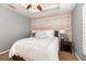 Comfortable bedroom features a wood accent wall, tray ceiling with fan, and a side table at 794 Lake Clark Ct, Lakeland, FL 33813