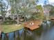 A charming property features a lakeside dock, a cozy swing, and inviting outdoor seating for enjoying the waterfront lifestyle at 794 Lake Clark Ct, Lakeland, FL 33813