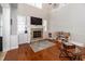 Cozy living room featuring hardwood floors, a stone fireplace, and built-in shelving for ample storage at 794 Lake Clark Ct, Lakeland, FL 33813