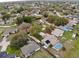 Aerial view displaying a neighborhood with lush greenery and a home featuring a screened pool at 7965 Kaitlin Cir, Lakeland, FL 33810