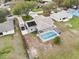 Aerial view showcasing a home with solar panels, a screened pool, and a spacious driveway at 7965 Kaitlin Cir, Lakeland, FL 33810