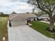 Aerial view of a well-kept home featuring a green lawn, two-car garage, and a long driveway at 7965 Kaitlin Cir, Lakeland, FL 33810