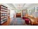 Sitting room featuring hardwood floors, piano, books and charming decor with natural lighting at 815 Success Ave, Lakeland, FL 33801