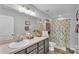 Well-lit bathroom with a large vanity, framed mirror, and decorative shower curtain at 8185 Woodvine Cir, Lakeland, FL 33810