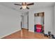 This bedroom has wood floors, an open closet, and a ceiling fan for added comfort at 8185 Woodvine Cir, Lakeland, FL 33810