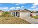 Charming single-story home featuring a two-car garage, a well-manicured lawn, and a welcoming front entrance at 8185 Woodvine Cir, Lakeland, FL 33810