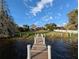 Scenic backyard view from the dock leading to a well-maintained lawn and a lovely home at 838 Lakeshore Dr, Polk City, FL 33868