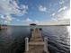 Beautiful waterfront view with a wooden dock extending into the calm lake with a gazebo at 838 Lakeshore Dr, Polk City, FL 33868