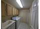 Functional laundry room with washer, dryer, sink, and storage cabinets at 838 Lakeshore Dr, Polk City, FL 33868