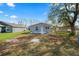 Street view of renovated house with green lawn, mature shade tree, and other houses in the background at 118 W Northside Dr, Lake Wales, FL 33853