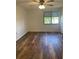 Bedroom with wood-look floors, ceiling fan, and window at 14 Buck Cir # 14, Haines City, FL 33844