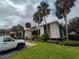 Exterior view of a multi-unit building with lush landscaping, green trim, and palm trees at 14 Buck Cir # 14, Haines City, FL 33844