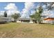 Wide shot of the beautiful backyard, showcasing the mature trees, and a fenced yard at 144 Lowell Rd, Winter Haven, FL 33884