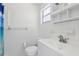 Bright bathroom features white tile, a vanity with sink, and a toilet at 144 Lowell Rd, Winter Haven, FL 33884