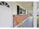 Charming front porch featuring brick accents, black shutters, and a welcoming entrance door at 144 Lowell Rd, Winter Haven, FL 33884