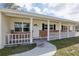 Inviting front porch with brick accents, white railing, and a clear view of the home's entrance at 144 Lowell Rd, Winter Haven, FL 33884