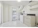 All-white laundry room features a washer, dryer, water heater, and convenient access door at 144 Lowell Rd, Winter Haven, FL 33884