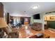 Open living room featuring hardwood floors, couches, a television, and access to the dining room at 144 Mirror Nw Ln, Winter Haven, FL 33881